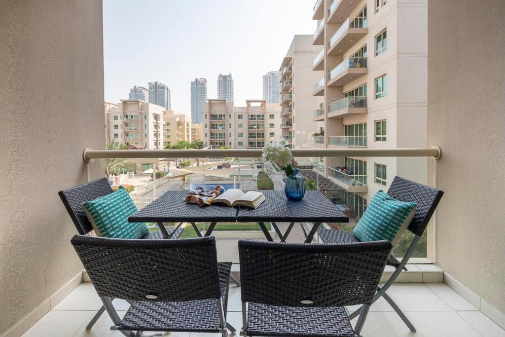 a balcony with a table and chairs with a view of a city at Frank Porter - Al Samar in Dubai