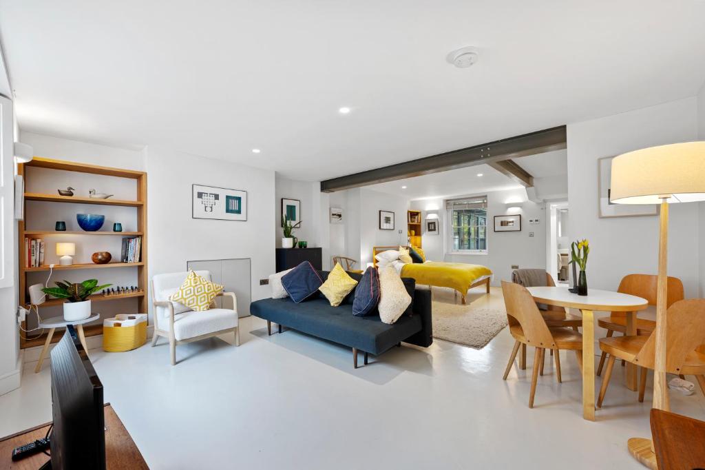 a living room with a blue couch and a table at Cosy, calm Camden Square studio in London