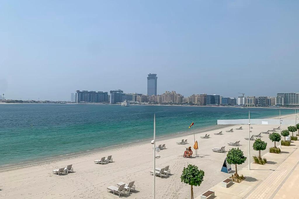 een strand met een stel stoelen en de oceaan bij Frank Porter - Beach Vista Tower 1 in Dubai