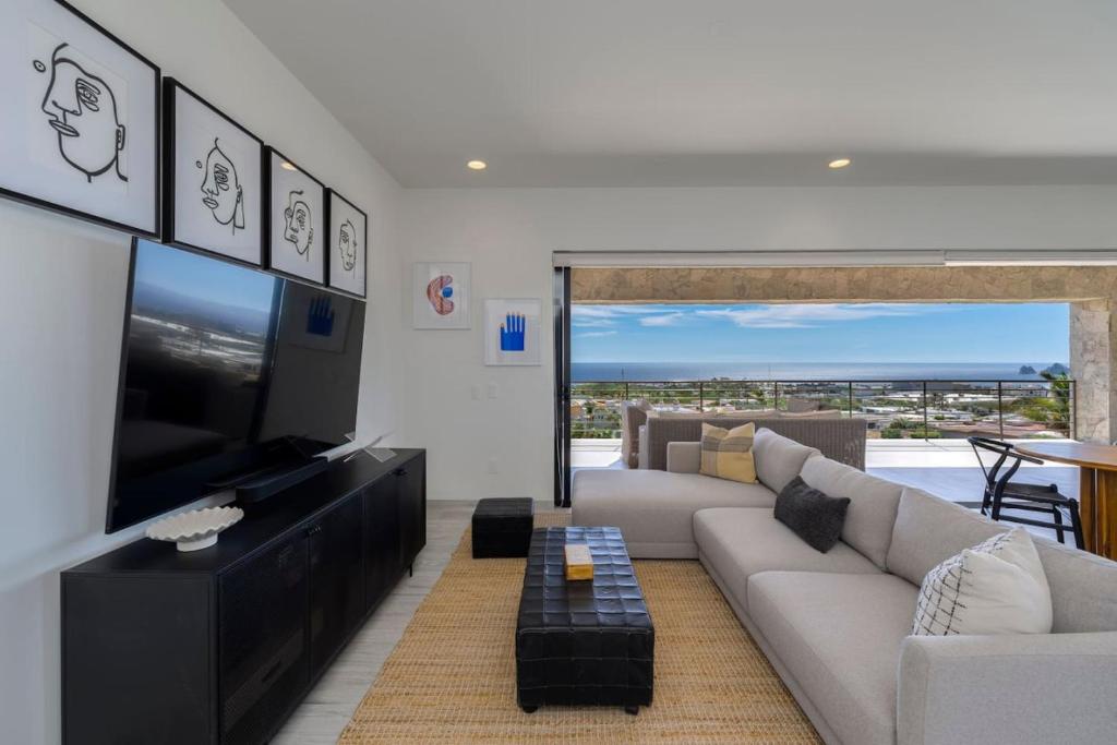 a living room with a couch and a tv at Spacious New 3BR Condo at Tramonti plus Resort Access in Cabo San Lucas
