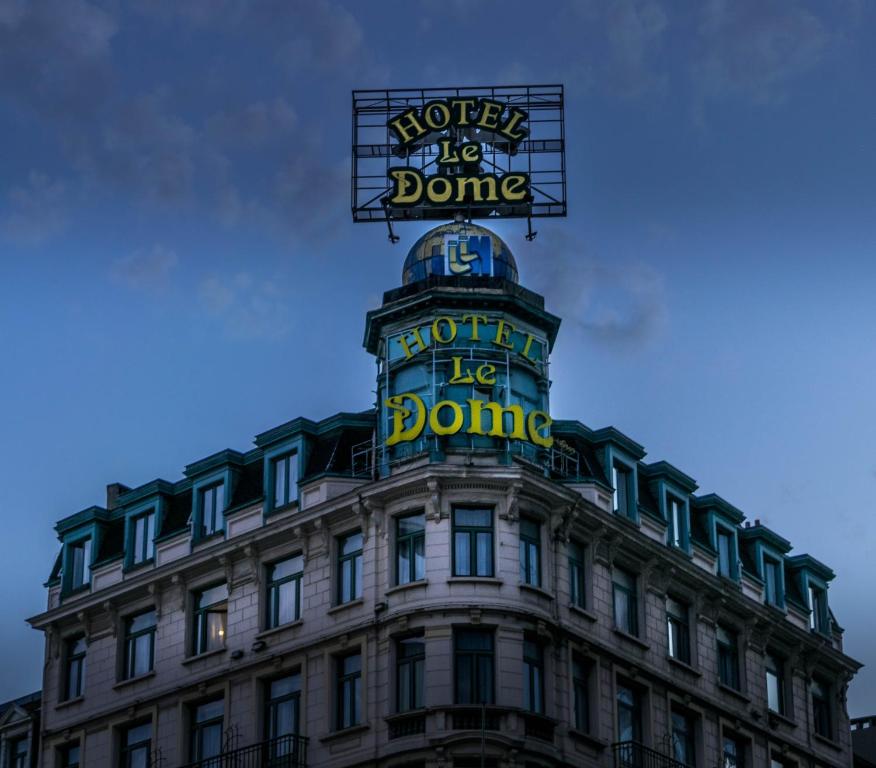 a building with a sign on the top of it at Hotel Le Dome in Brussels