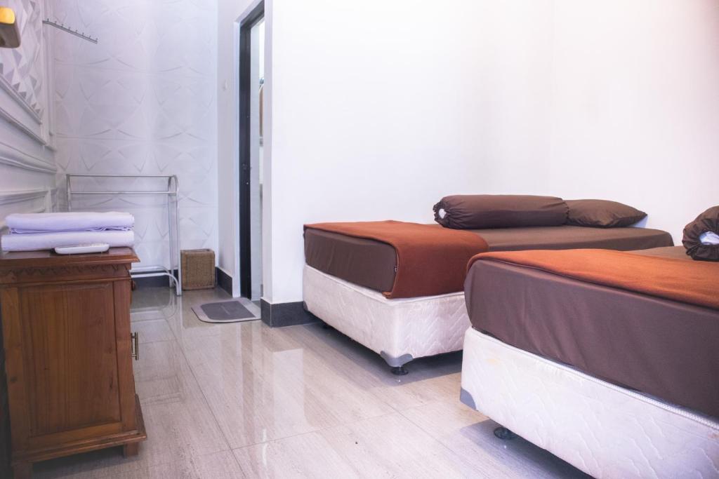 Cette chambre comprend 2 lits et une table en bois. dans l'établissement KAZAIN HOTEL, à Timuran