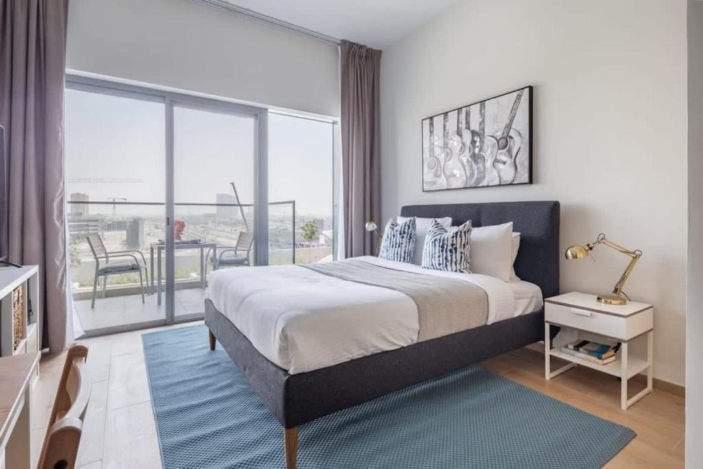 a bedroom with a large bed and a large window at Frank Porter - Azizi Aura in Dubai