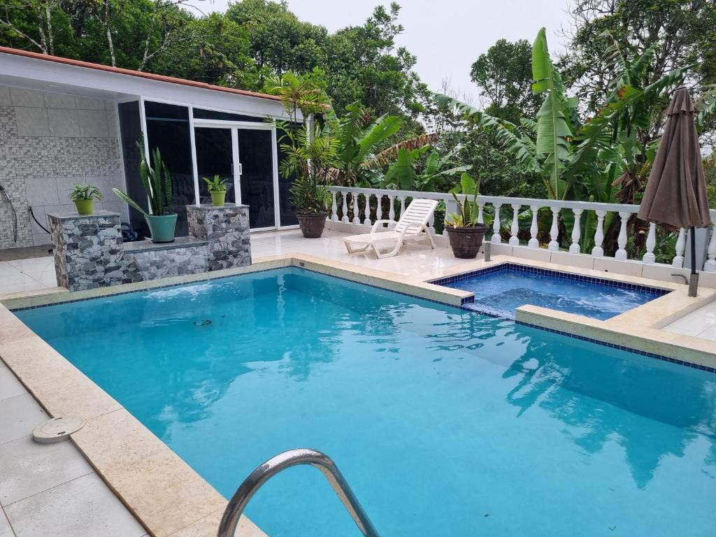 una piscina con patio y una casa en Villa Helena en Los Altos de Cerro Azul