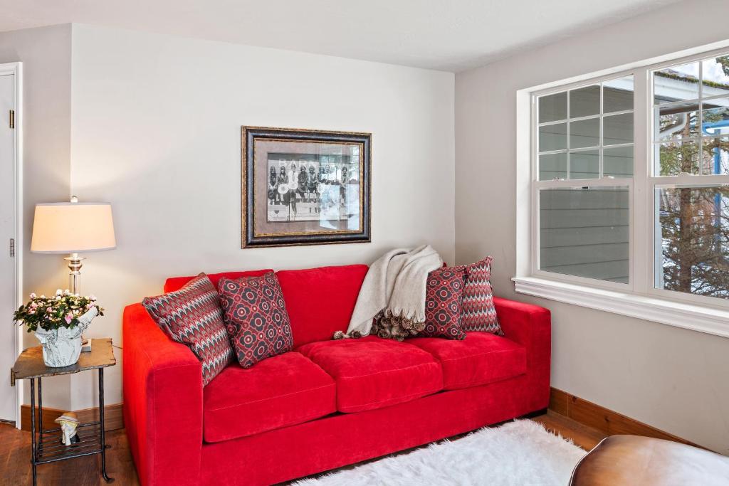 a red couch in a living room with a window at 30-Day Min Near Lake and Downtown Whitefish in Whitefish
