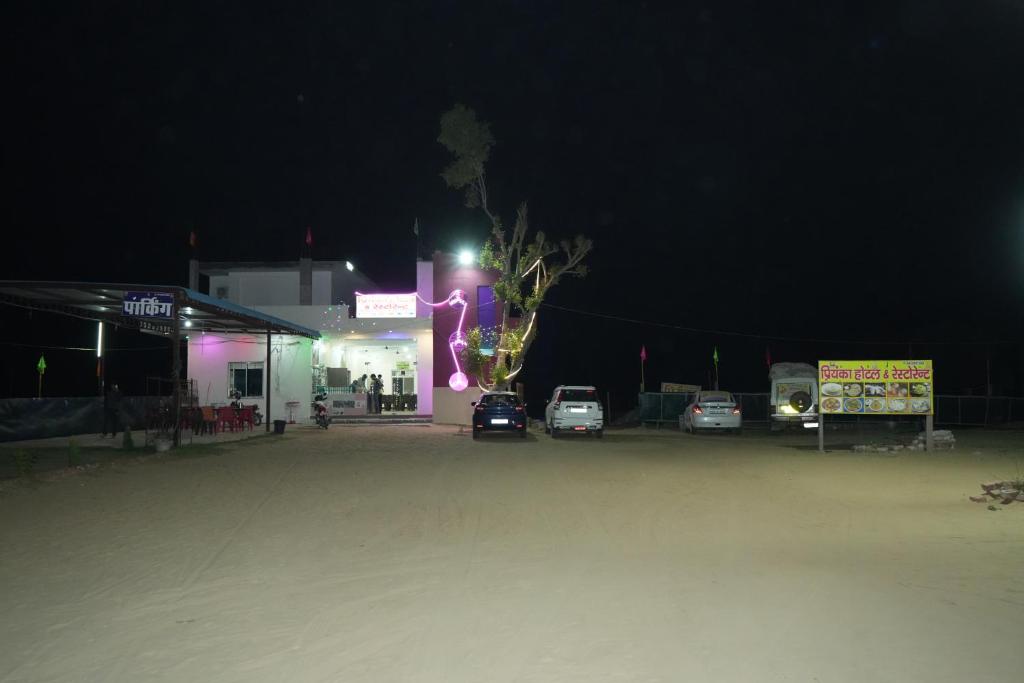 - un parking de nuit avec un arbre au milieu dans l'établissement Priyanka hotel & Restaurant khatushyam ji, à Khātu