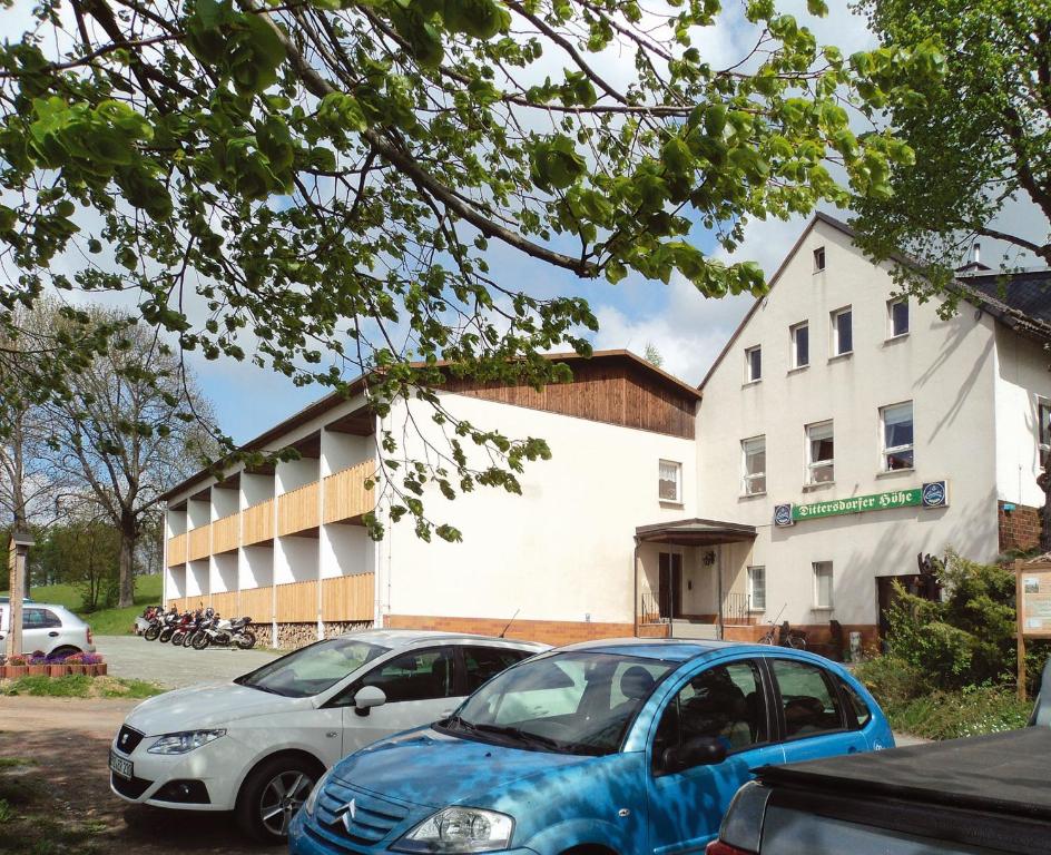two cars parked in a parking lot in front of a building at Landgasthof Dittersdorfer Höhe in Amtsberg