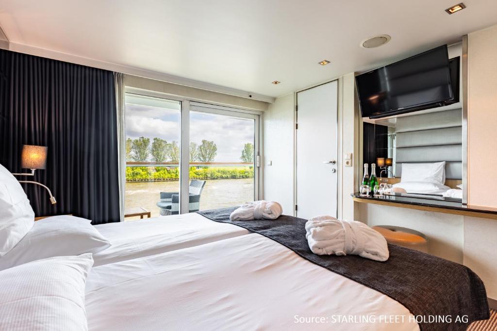 a bedroom with a large bed with two towels on it at KD Hotelship Frankfurt Untermainkai in Frankfurt/Main
