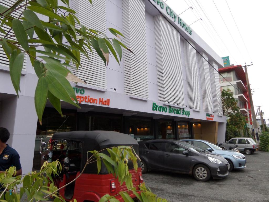 un edificio con coches estacionados frente a él en Bright Bravo Hotel, en Kurunegala