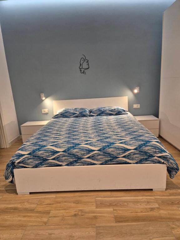 uma cama com um edredão azul e branco num quarto em Casa Vacanze Aenaria 2 em Ischia