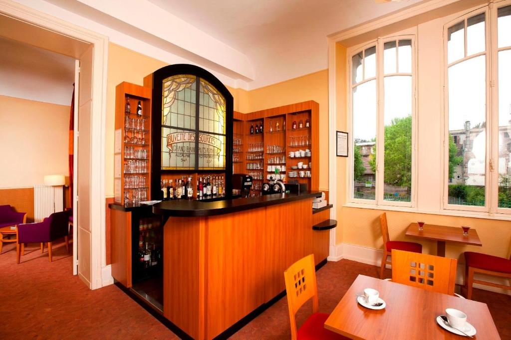 a bar in a library with chairs and tables at Hotels &amp; Résidences - Les Thermes in Luxeuil-les-Bains