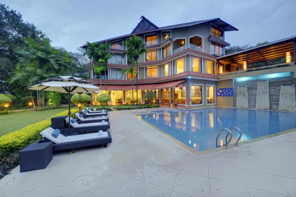 a house with a swimming pool in front of a house at The Crown Goa in Panaji