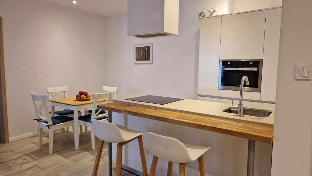 a kitchen with a counter and a table and chairs at Perfect Location Comfort Apartment City Beat#10 in Krakow