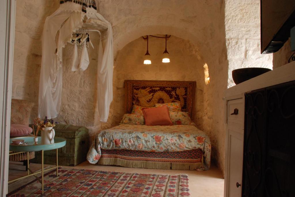 ein Schlafzimmer mit einem Bett in einer Steinmauer in der Unterkunft Conibianchi Trulli&YurtArt House in Ceglie Messapica