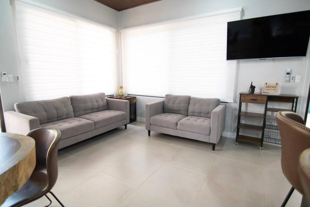 uma sala de estar com 2 sofás e uma televisão de ecrã plano em Tortuga House Playa Avellanas em Playa Avellana
