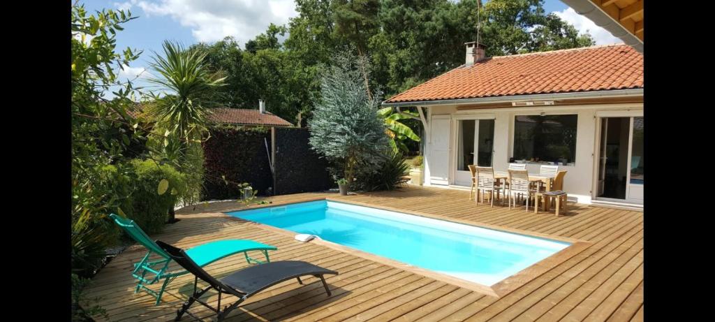 Un patio trasero con piscina y una casa. en Chambre proche du littoral., en Marcheprime