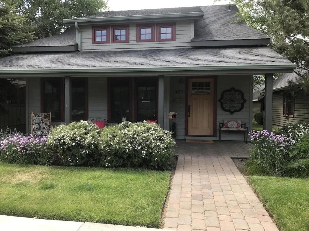 a house with a front door and flowers at Steps to Downtown & Amazing Views-Hot Tub/Pool/AC in Sisters
