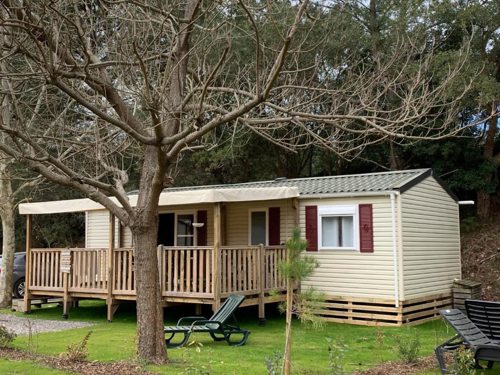 a small yellow house with a large deck at Mobile Home Village Vacances Océan et Nature in Seignosse