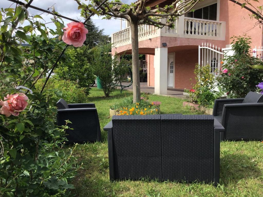 un jardín con sillas y flores frente a una casa en Appartement Vals les bains, en Vals-les-Bains