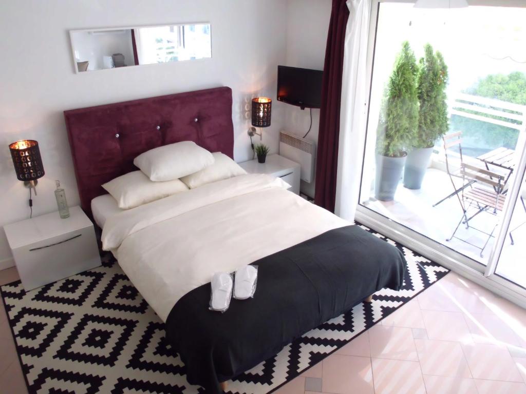a bedroom with a large bed and a large window at Monaco Beach Balcony Apartments in Beausoleil