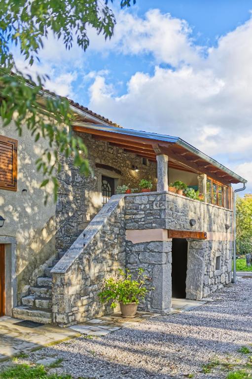 kamienny dom z werandą i balkonem w obiekcie Apartman studio Baladur w mieście Roč