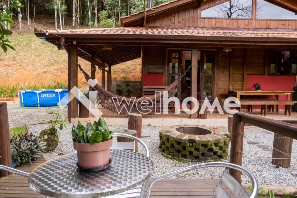 einen Tisch und Stühle vor einem Haus in der Unterkunft Casa com área de lazer e vista para as montanhas in Aguas Mornas