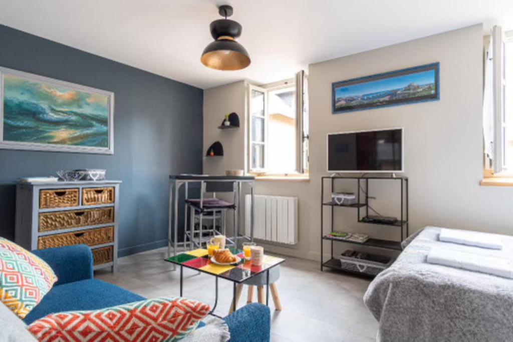 un salon avec un canapé et une table dans l'établissement Norman studio in city center, à Honfleur