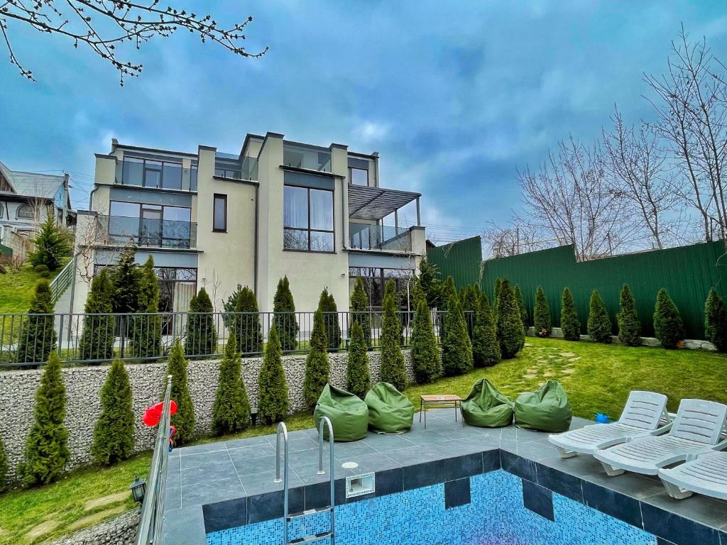 uma casa com piscina em frente a uma casa em Prive Villa em Durleşti