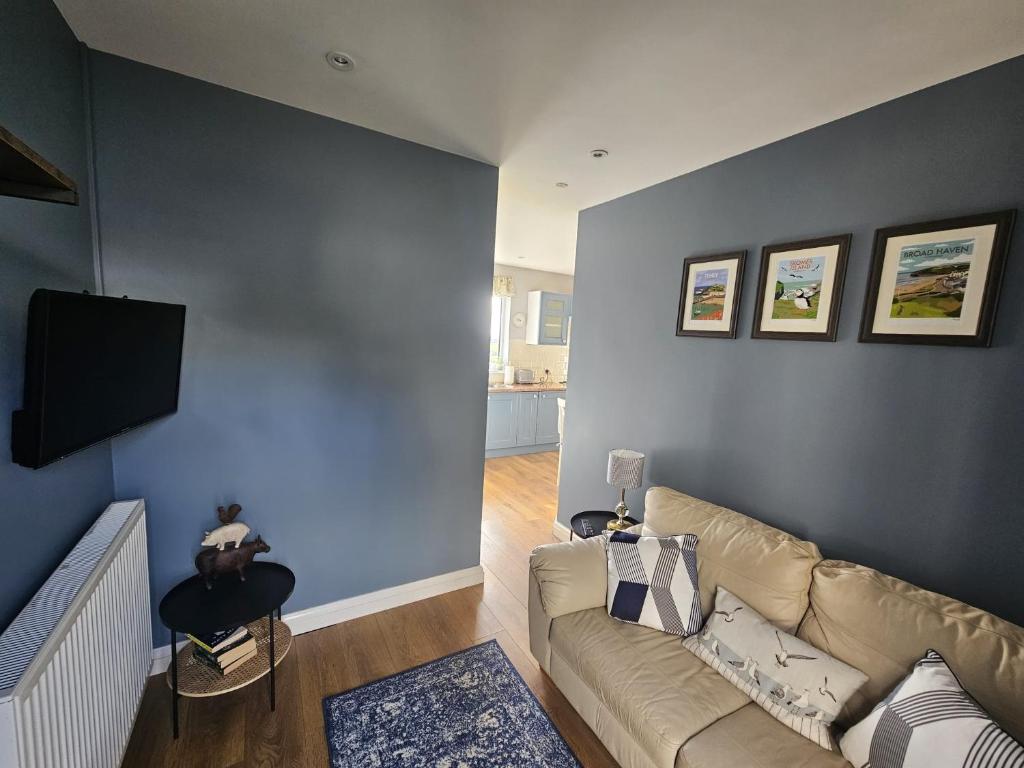 un soggiorno con divano e parete blu di Meadow cottage a Haverfordwest