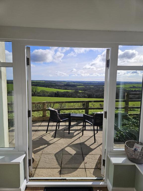 a balcony with a view of the countryside through a glass door at Meadow View in Haverfordwest