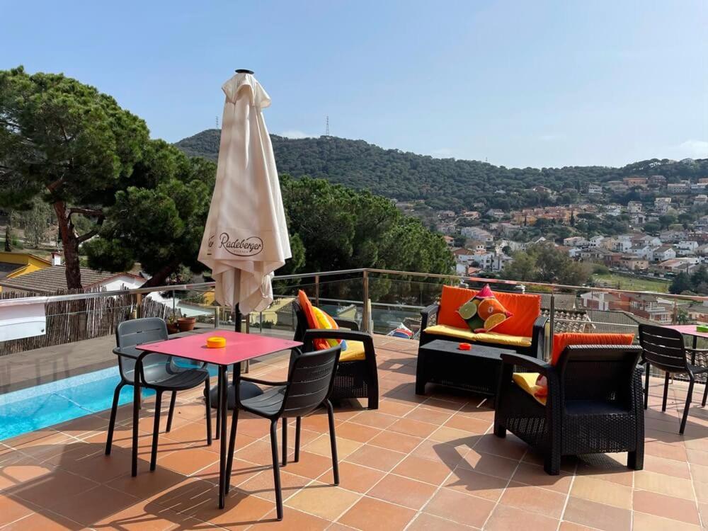 um pátio com uma mesa, cadeiras e um guarda-sol em Habitaciones en Villa Coliving Villa Vistas em San Fausto de Campcentellas