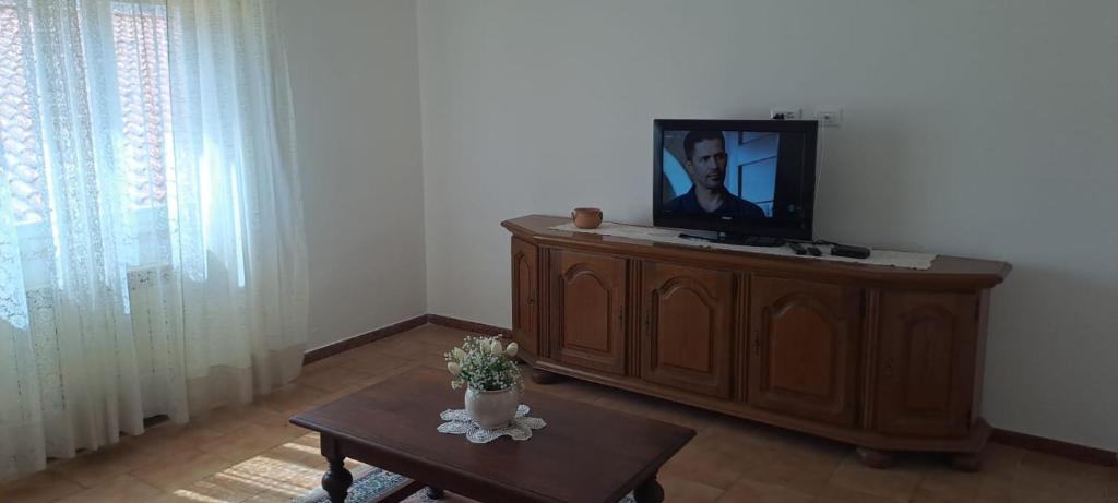 Casa Simy في فادا: غرفة معيشة مع تلفزيون على خزانة خشبية