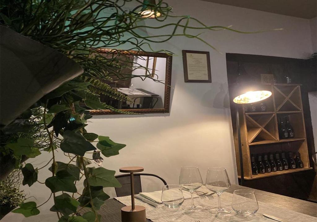 a table with wine glasses and a mirror on the wall at Rent House Scauri in Minturno
