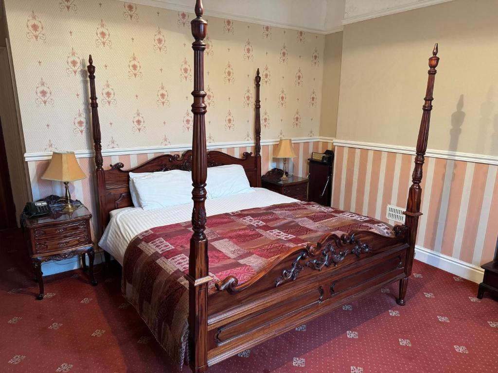 um quarto com uma grande cama de madeira num quarto em The Chetwynde em Barrow in Furness