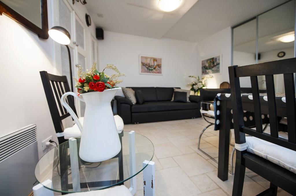 a living room with a vase with flowers in it at Apartment Art in Rovinj