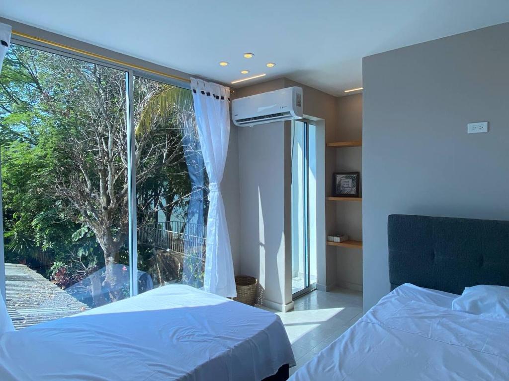 普拉多的住宿－Cabaña de Lujo, Isla El Faro，一间卧室设有两张床和大窗户