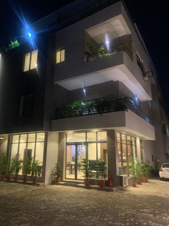 un edificio de noche con plantas delante en Greywood Hotel and Apartments, en Ikeja