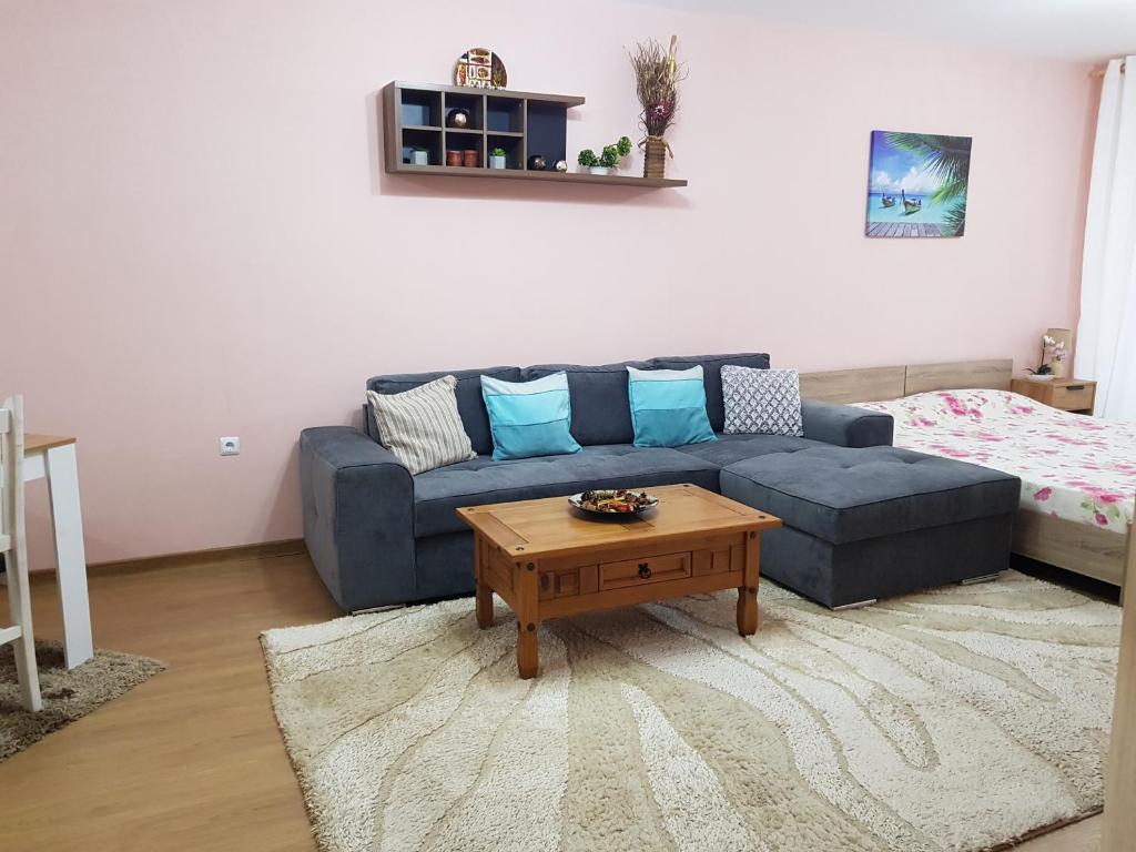 a living room with a blue couch and a coffee table at Sarafovo Sea Paradise in Burgas City