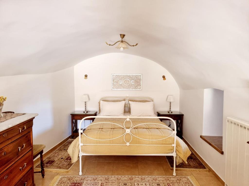 1 dormitorio con 1 cama en una habitación blanca en Stone Suites and Villas, en Levidhion