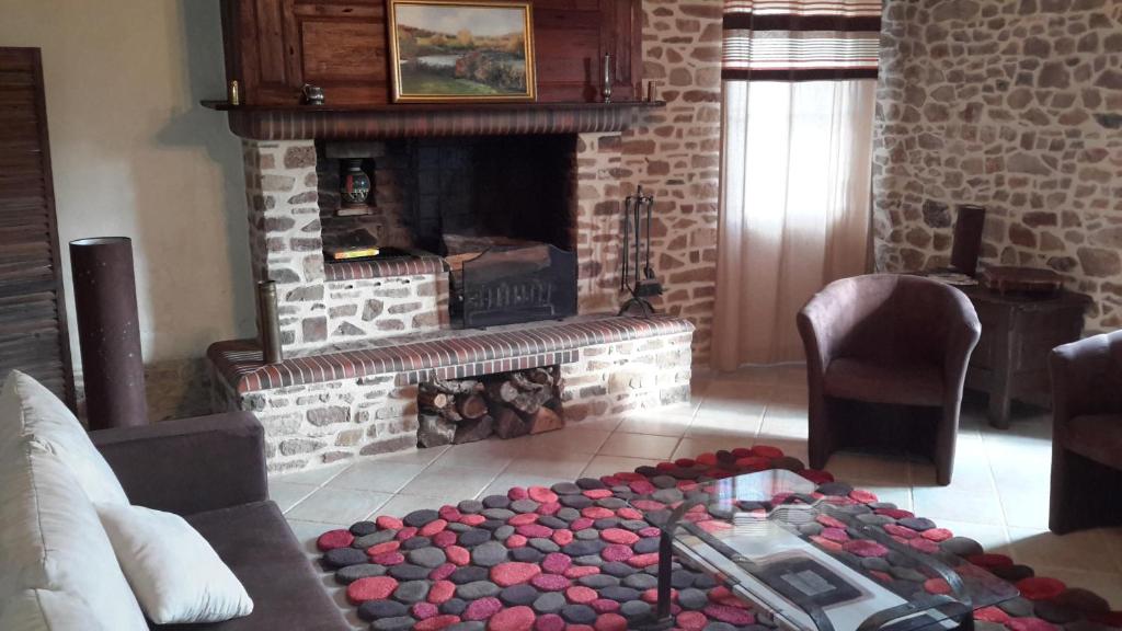 a living room with a brick fireplace with a coffee table at Gîte De L&#39;Etot Fossey in Marchésieux