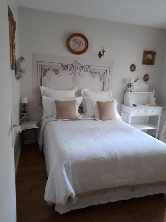 a white bedroom with a white bed with pillows at Chambre d'hôtes avec garage au bord de mer in Toulon