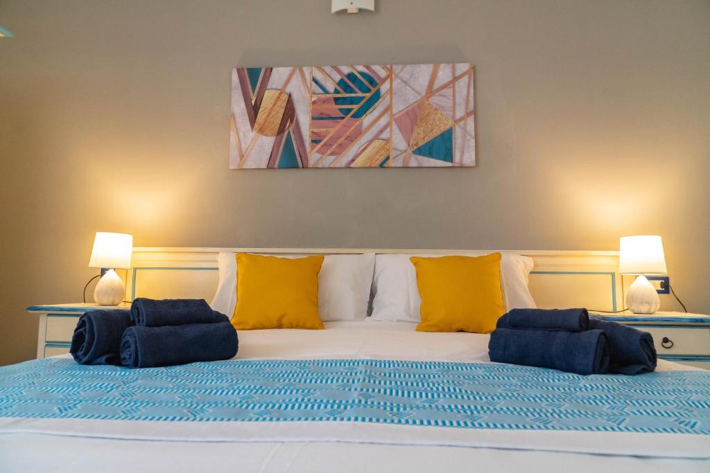 ein Bett mit zwei blauen Kissen darüber in der Unterkunft Sabbia & mare in Porto Torres