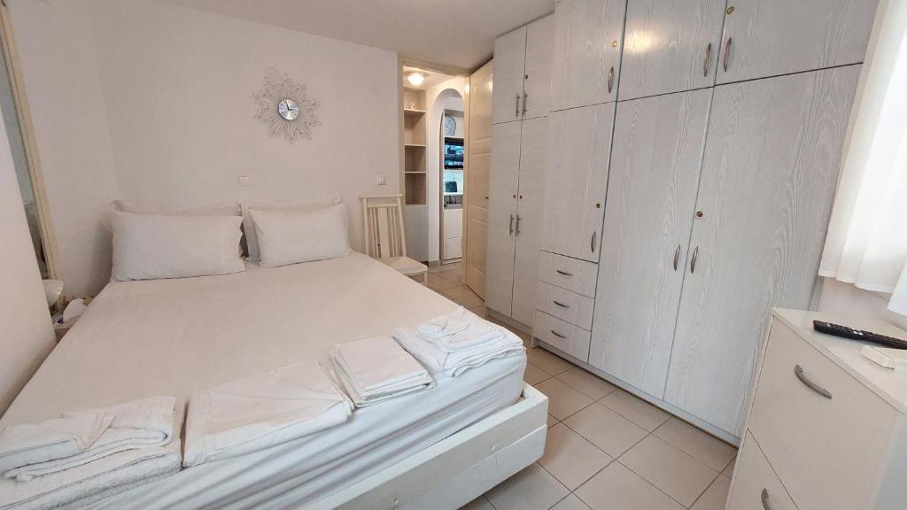 a white bedroom with a bed and white cabinets at Belva Blue Naxos Stylish, Naxos Town, near Beach in Naxos Chora