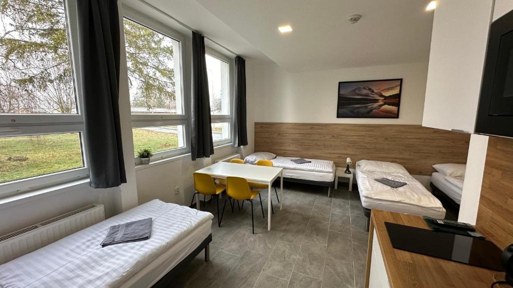a room with two beds and a table at Hotel Hangar in Mošnov