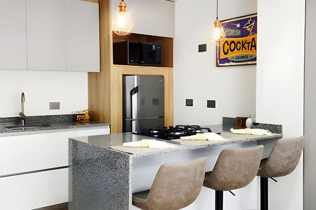 a kitchen with a counter with a stove and chairs at 202 Norte cali - The view in Cali