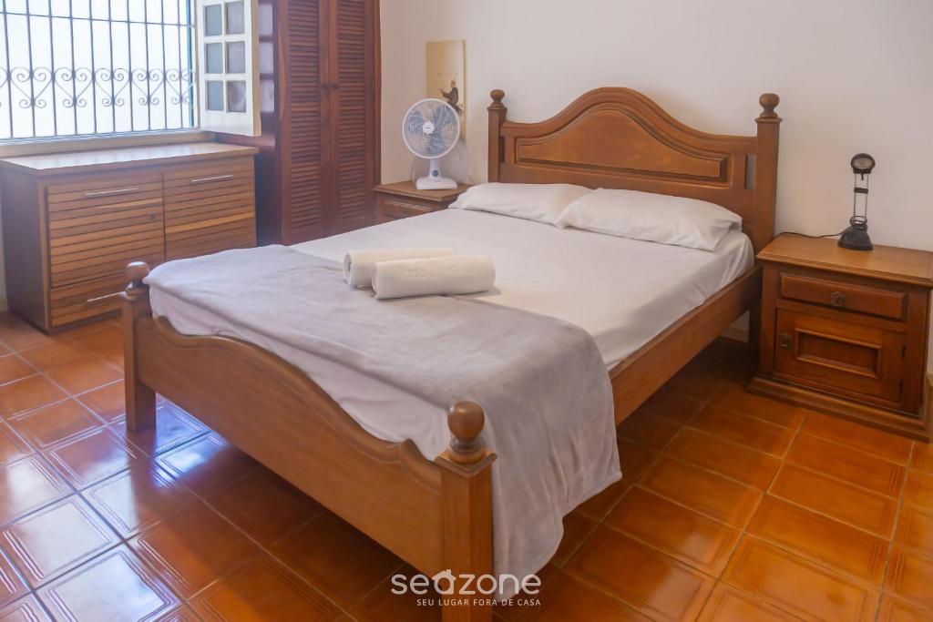 a bedroom with a bed and a fan and a window at Elegante Apto a 3 minutos da Praia Grande BTI003 in Ubatuba