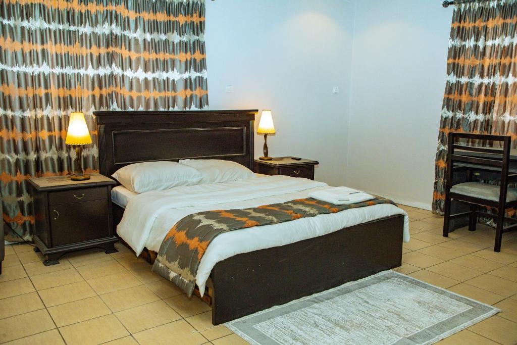 a bedroom with a large bed with two night stands at Urban View Lodge - Apt.5 Room 1 in Abuja