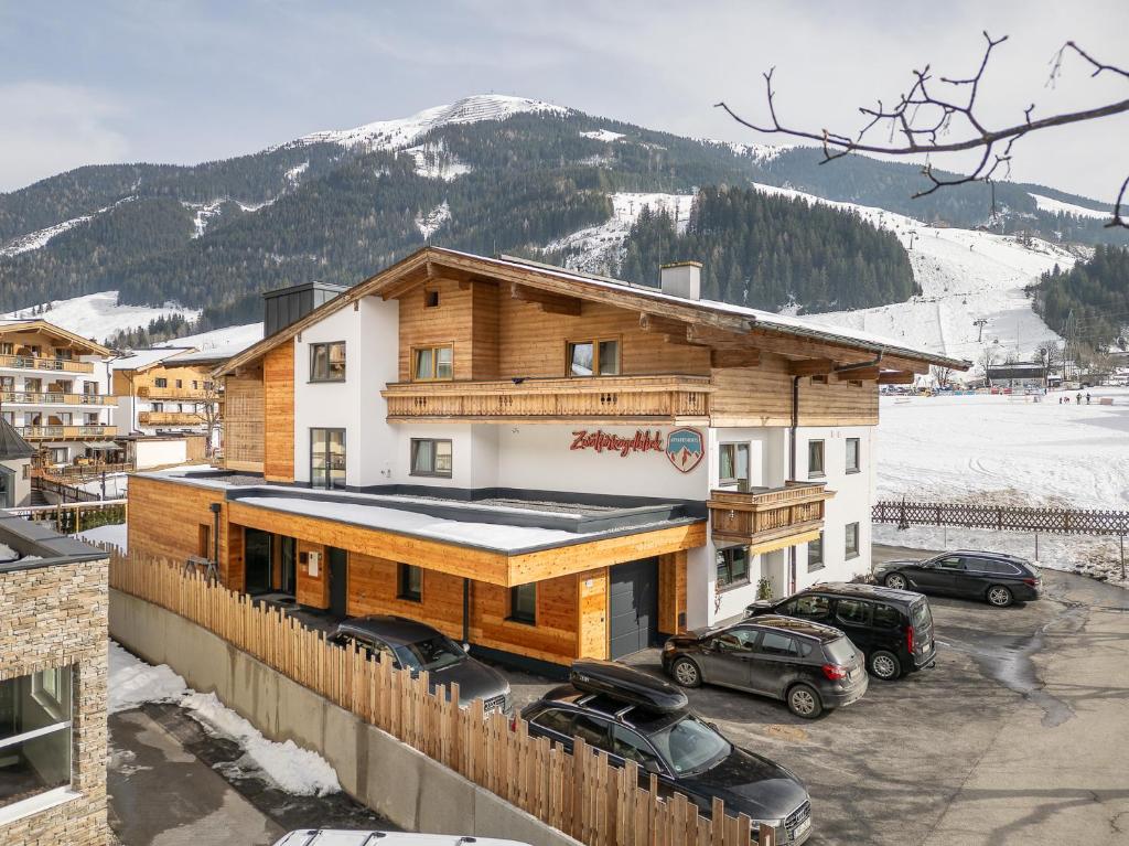 un bâtiment avec des voitures garées dans un parking dans l'établissement Appartements Zwölferkogelblick, à Saalbach-Hinterglemm