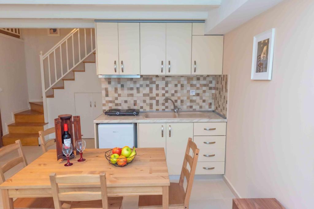 una cucina con tavolo in legno e cesto di frutta di INFINITY SEASIDE APARTMENTS a Nea Kalikratia