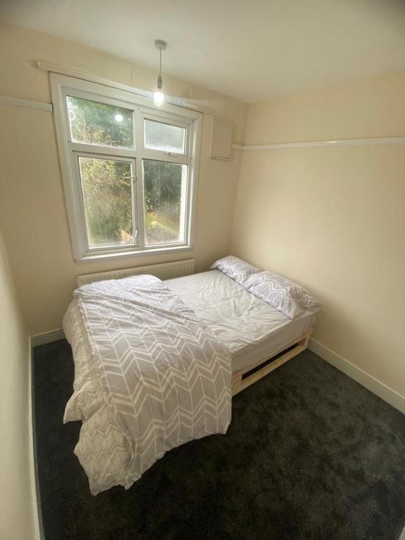 a small bedroom with a bed with a window at Best room- Near London luton Airport and close to Restaurants shops and Dunstable hospital in Luton
